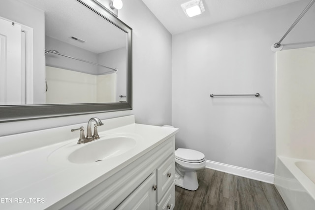 full bathroom with vanity, hardwood / wood-style flooring, bathtub / shower combination, and toilet