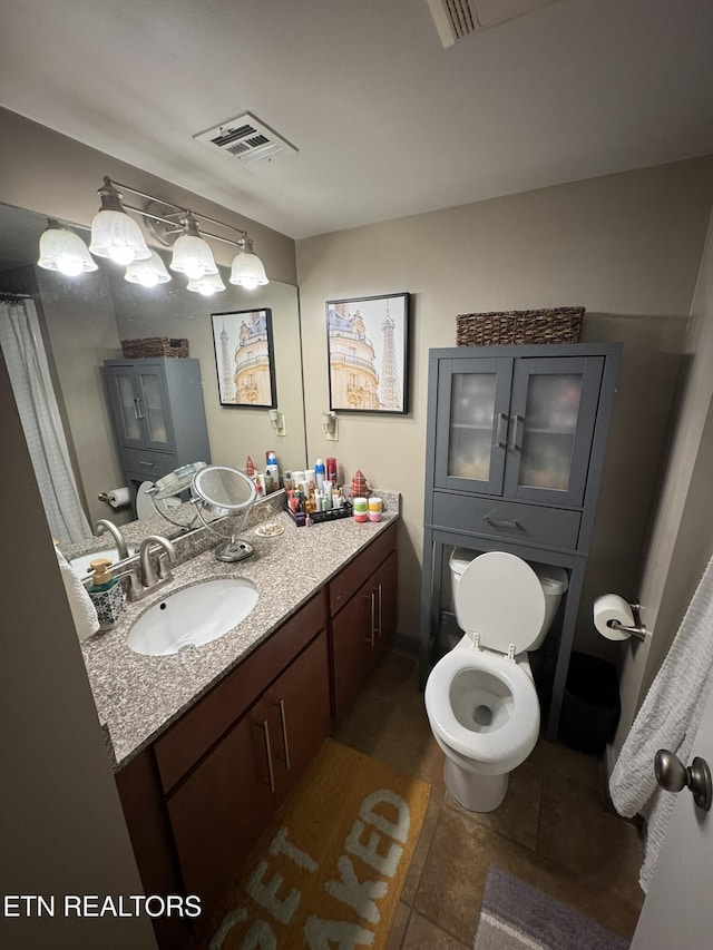 bathroom with vanity, tile patterned floors, and toilet