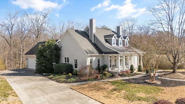 view of side of property featuring a garage and covered porch