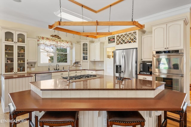 kitchen featuring a spacious island, appliances with stainless steel finishes, sink, and decorative backsplash