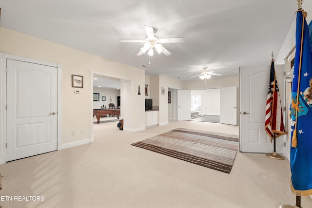 interior space with carpet floors and ceiling fan