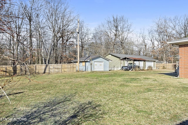 view of yard with a carport, a garage, and an outdoor structure