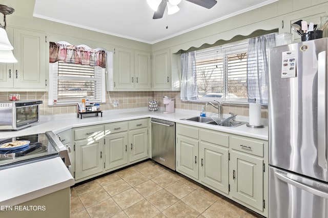 kitchen with sink, crown molding, decorative light fixtures, appliances with stainless steel finishes, and decorative backsplash