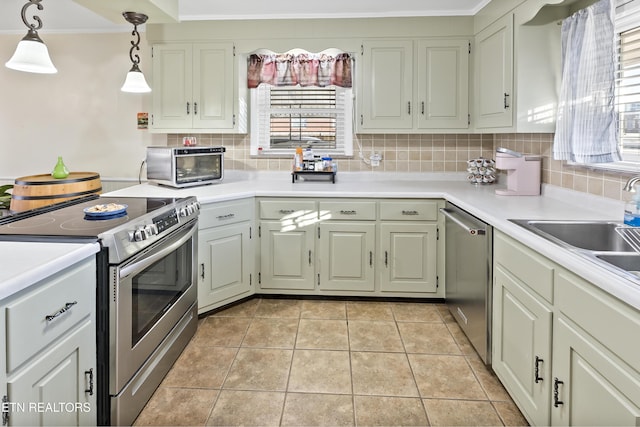 kitchen with crown molding, light tile patterned floors, appliances with stainless steel finishes, pendant lighting, and backsplash