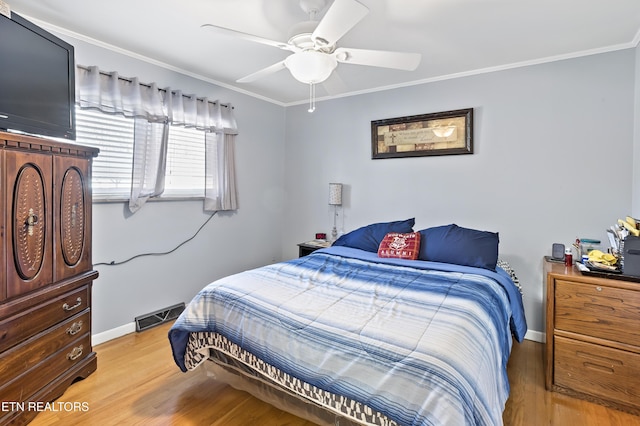 bedroom featuring ceiling fan, ornamental molding, and wood-type flooring