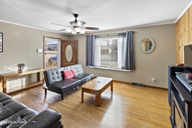 living room with ceiling fan, ornamental molding, and light hardwood / wood-style flooring