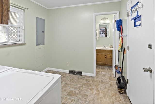 clothes washing area featuring ornamental molding, sink, electric panel, and washer and clothes dryer