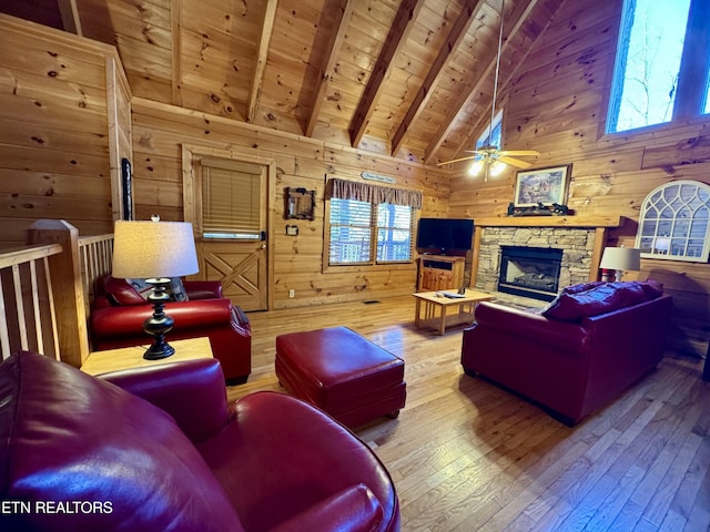 living room featuring wood ceiling, hardwood / wood-style flooring, a fireplace, beamed ceiling, and wood walls