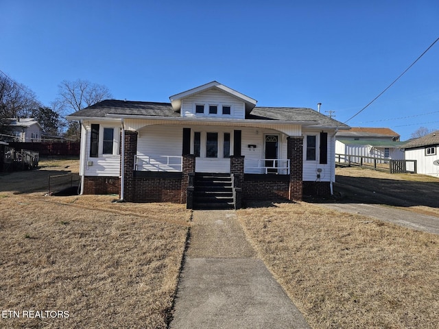 bungalow-style home with a porch and a front lawn