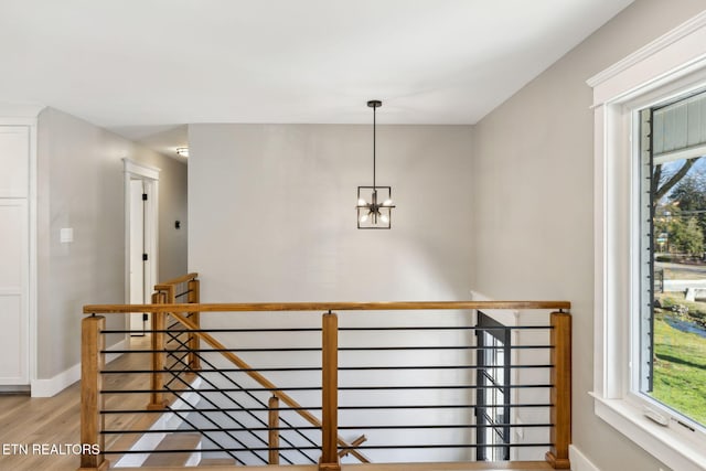 stairs featuring hardwood / wood-style floors and a notable chandelier