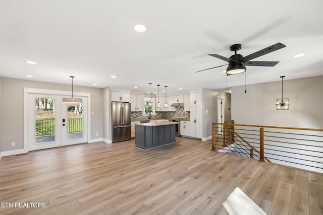 living room with light hardwood / wood-style flooring, french doors, and ceiling fan