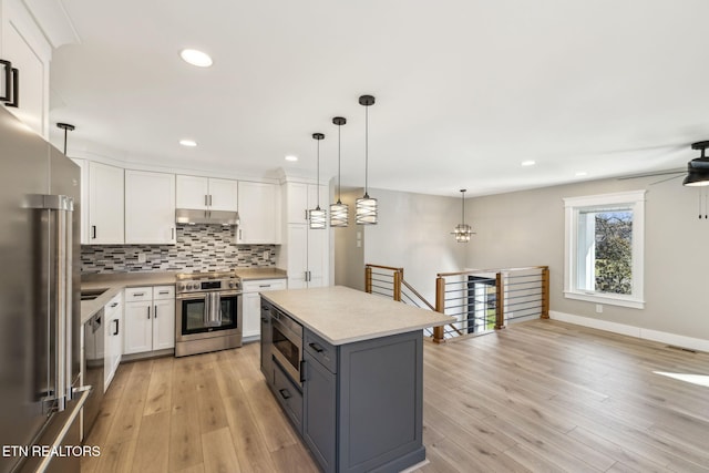 kitchen featuring white cabinetry, hanging light fixtures, and stainless steel appliances