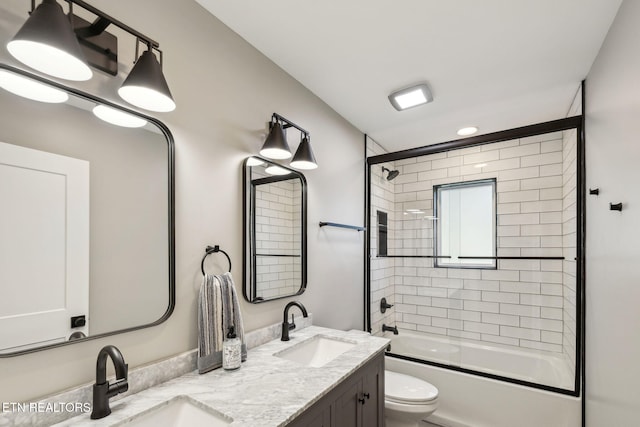 full bathroom featuring enclosed tub / shower combo, vanity, and toilet