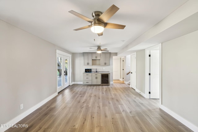 unfurnished living room with wine cooler and light wood-type flooring