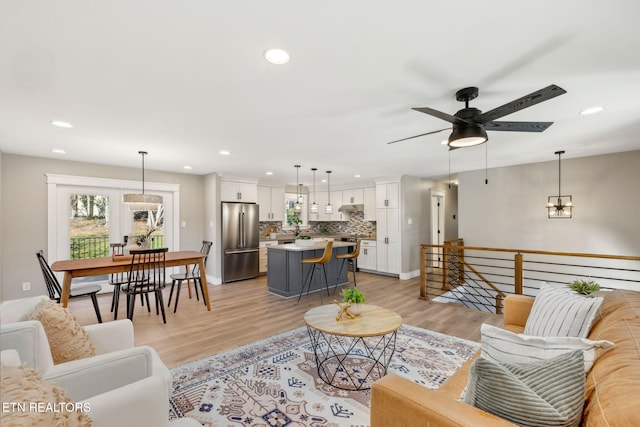 living room featuring ceiling fan and light hardwood / wood-style flooring