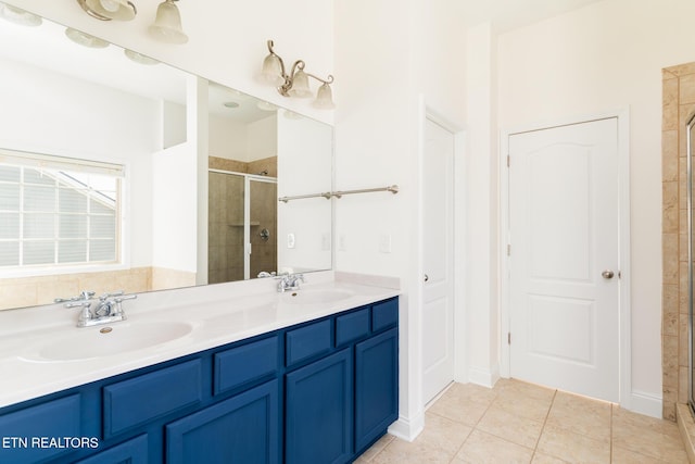 bathroom featuring tile patterned floors, a shower with shower door, and vanity