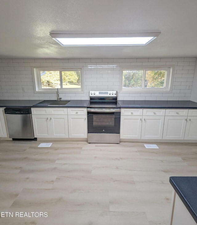 kitchen with white cabinetry, appliances with stainless steel finishes, sink, and plenty of natural light