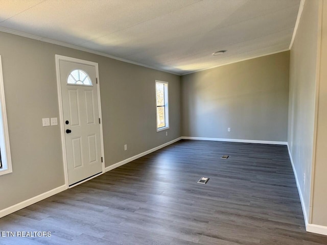 foyer entrance with crown molding and dark hardwood / wood-style flooring