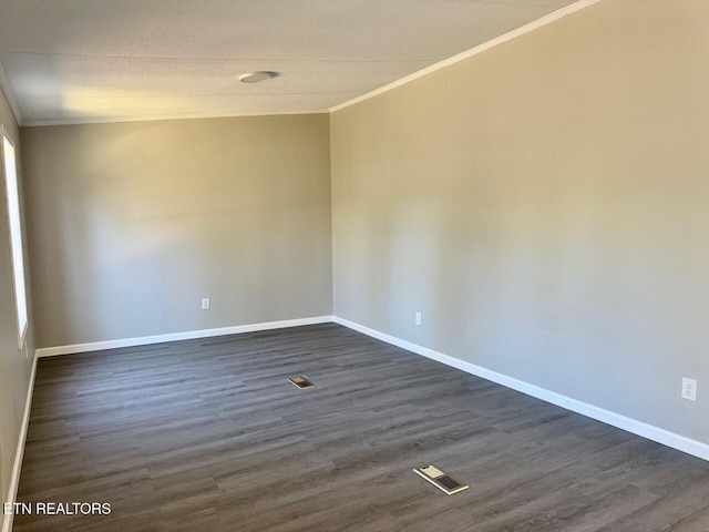 empty room with crown molding and dark hardwood / wood-style floors