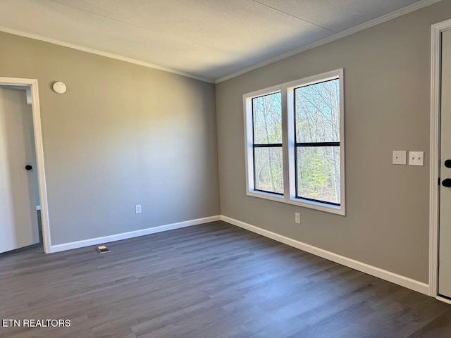 empty room featuring crown molding and dark hardwood / wood-style flooring