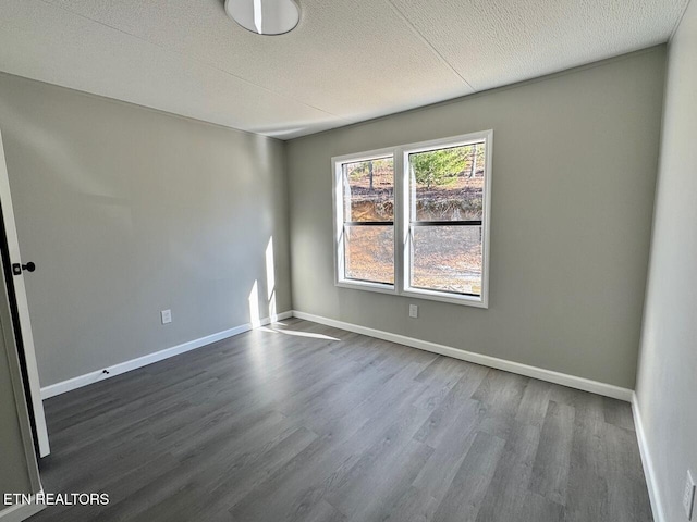 unfurnished room featuring dark hardwood / wood-style floors and a textured ceiling