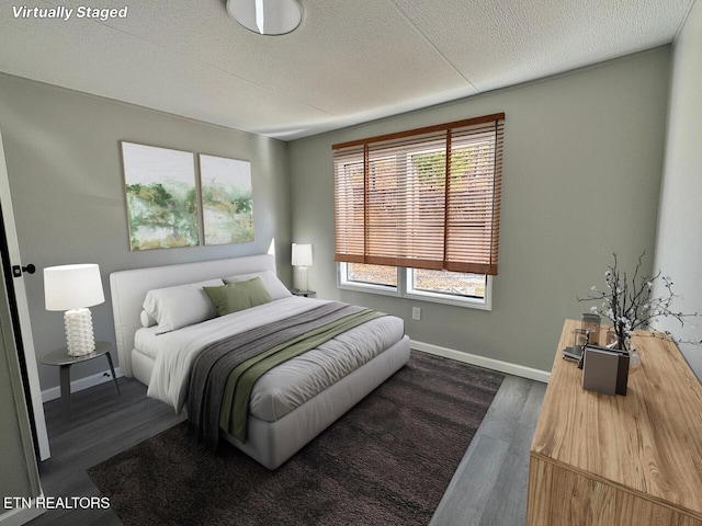 bedroom with dark hardwood / wood-style flooring and a textured ceiling