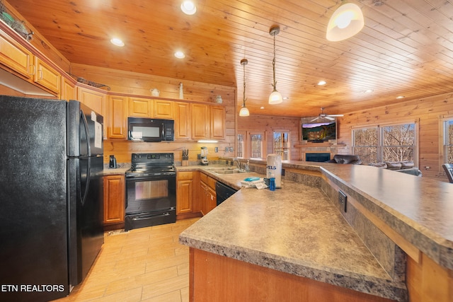 kitchen featuring sink, a stone fireplace, black appliances, decorative light fixtures, and wooden ceiling