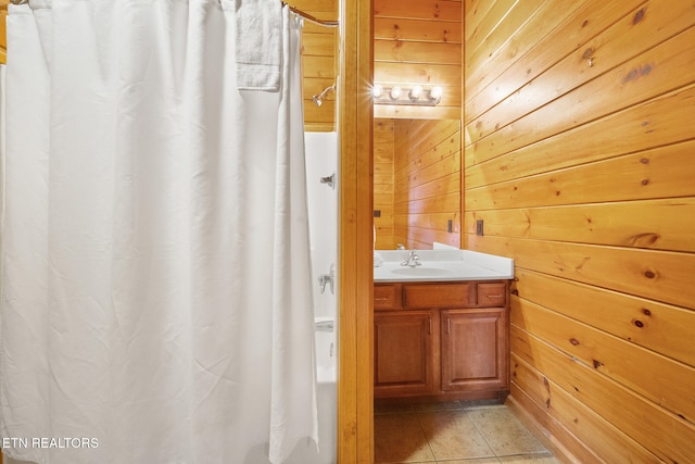 bathroom featuring vanity, tile patterned floors, and wooden walls