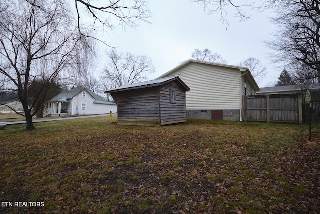 view of side of property featuring a yard and a shed