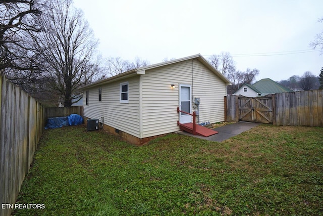 rear view of property featuring a yard and central AC