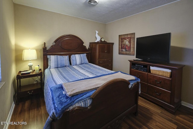 bedroom featuring dark wood-type flooring and a textured ceiling