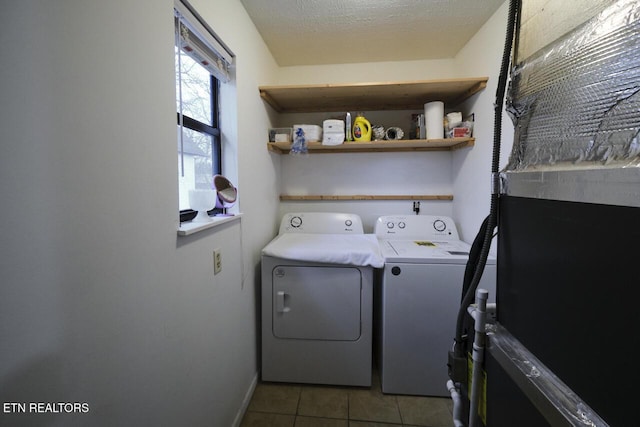 laundry area with washing machine and dryer, light tile patterned floors, and a textured ceiling