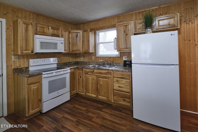 kitchen featuring sink, white appliances, dark wood-type flooring, and a textured ceiling