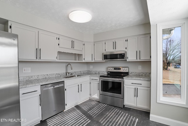 kitchen with appliances with stainless steel finishes, sink, and white cabinets