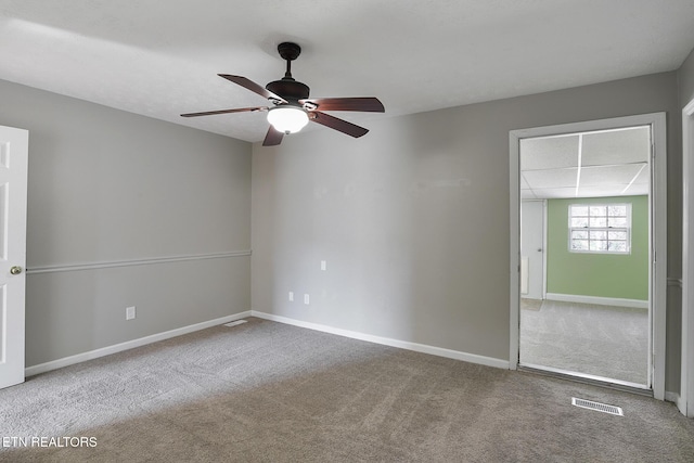 carpeted spare room featuring ceiling fan