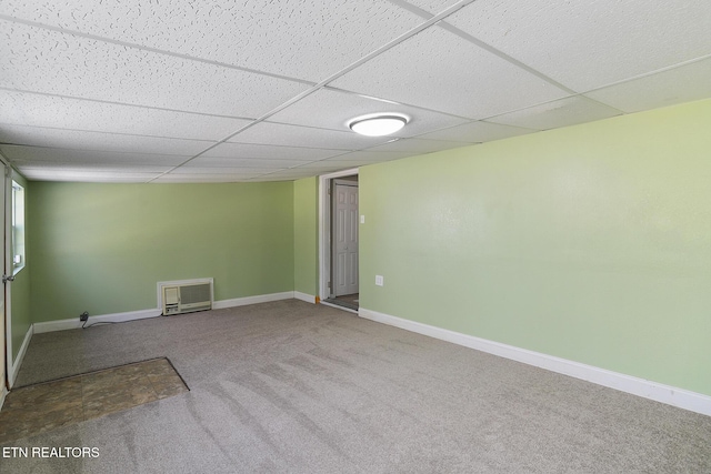 carpeted spare room with a drop ceiling