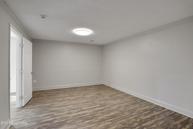 spare room featuring ornamental molding, dark hardwood / wood-style floors, and a textured ceiling