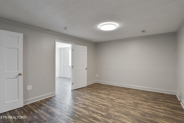 spare room featuring crown molding, dark hardwood / wood-style floors, and a textured ceiling