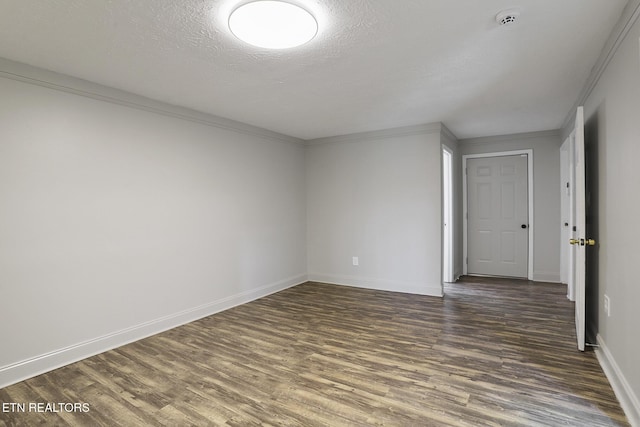 empty room featuring crown molding, dark hardwood / wood-style floors, and a textured ceiling