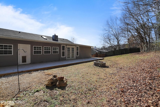 back of property featuring a wooden deck, an outdoor fire pit, and french doors