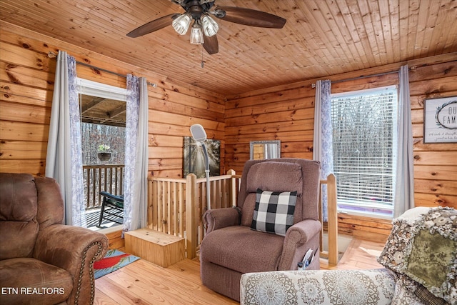 living area featuring wood ceiling, wooden walls, and light hardwood / wood-style floors