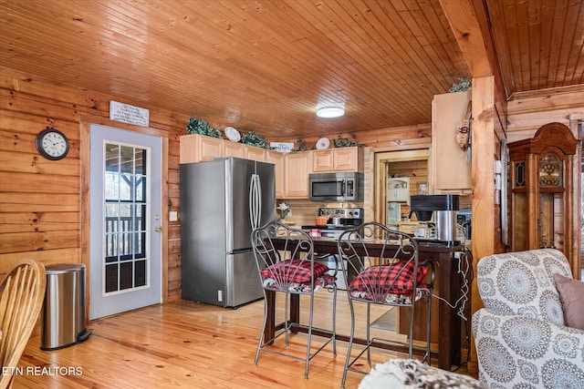 kitchen with wooden walls, stainless steel appliances, light hardwood / wood-style floors, light brown cabinetry, and wooden ceiling