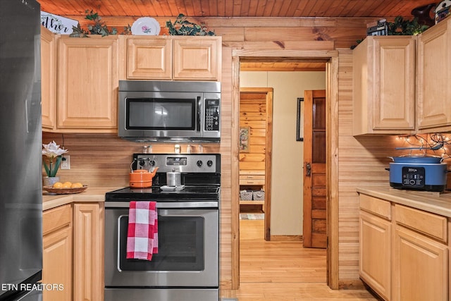 kitchen with light brown cabinetry, wood ceiling, light wood-type flooring, and appliances with stainless steel finishes