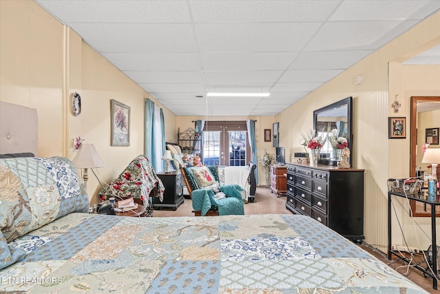 bedroom featuring a drop ceiling and french doors