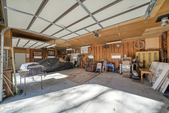 garage featuring a garage door opener and wood walls