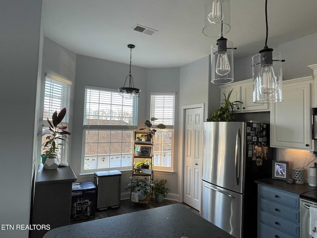 kitchen with white cabinetry, decorative light fixtures, stainless steel fridge, and dark hardwood / wood-style floors