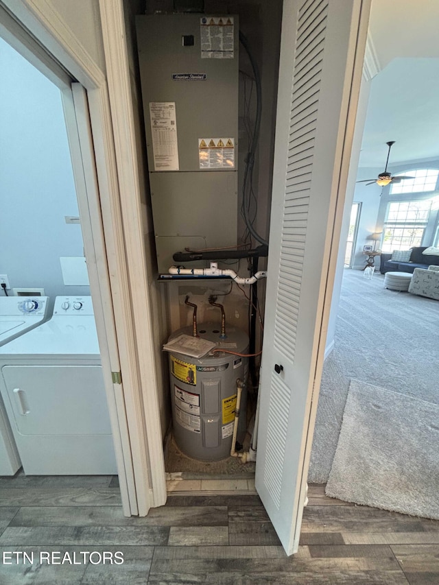 utility room with electric water heater, heating unit, and washing machine and clothes dryer