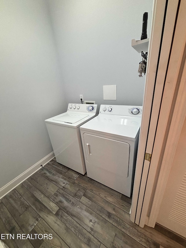 clothes washing area featuring washing machine and clothes dryer and dark hardwood / wood-style floors