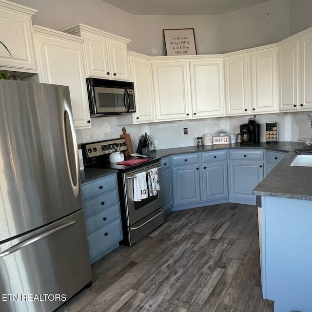 kitchen featuring stainless steel appliances, dark hardwood / wood-style floors, sink, and white cabinets