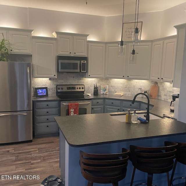 545 Rarity Bay Pkwy Apt 207, Vonore, TN 37885 - kitchen featuring appliances with stainless steel finishes, dark countertops, a sink, and tasteful backsplash